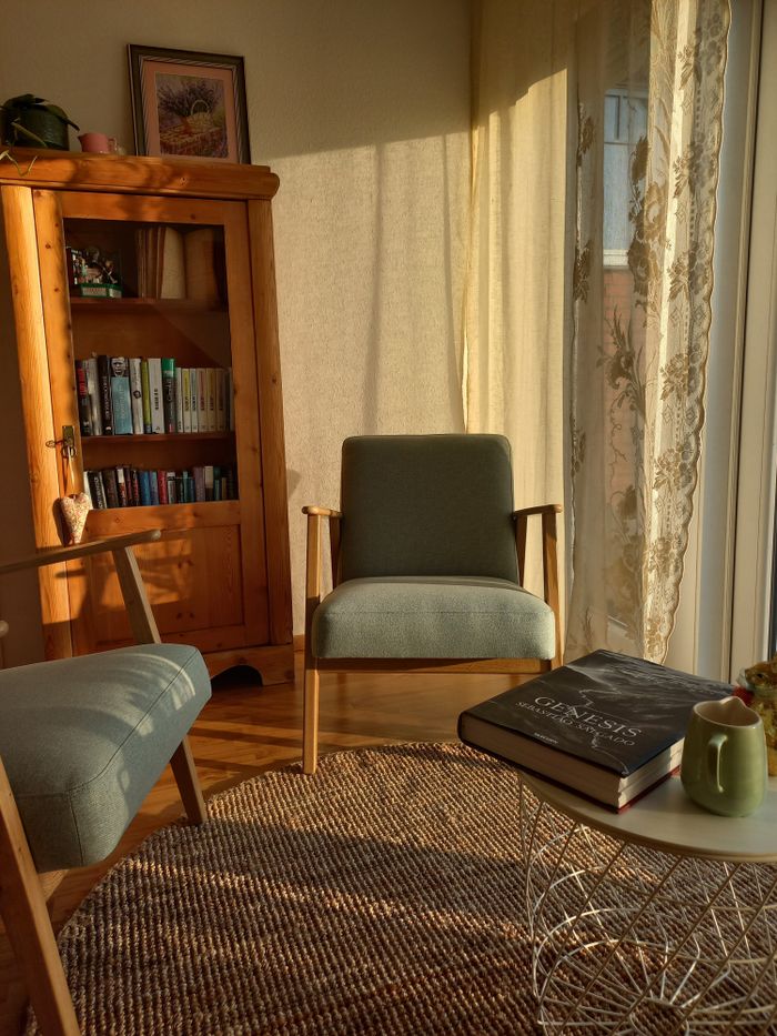 Warm sunlit reading nook featuring vintage furniture and a cozy atmosphere.